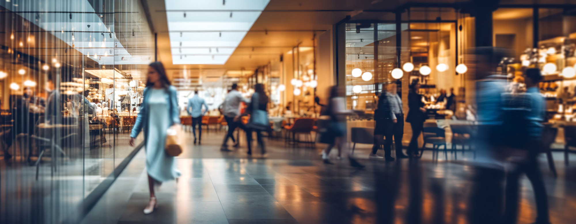 Blurred background of a modern shopping mall with some shoppers.